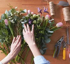 Hands arranging a fresh flower bouquet with secateurs