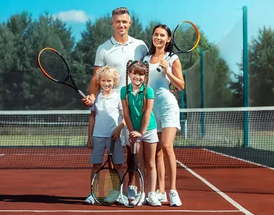 A family with tennis rackets on court