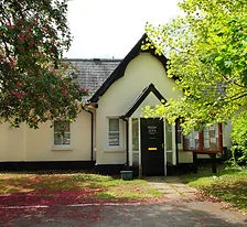A community building on a tree-lined common