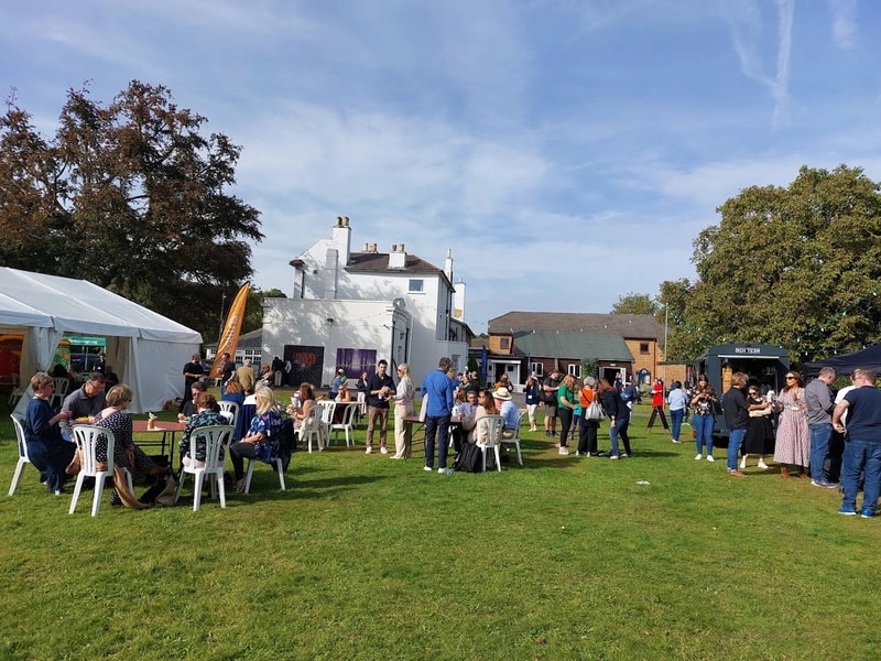Crowds gathered under a marquee at a GXCA community fete
