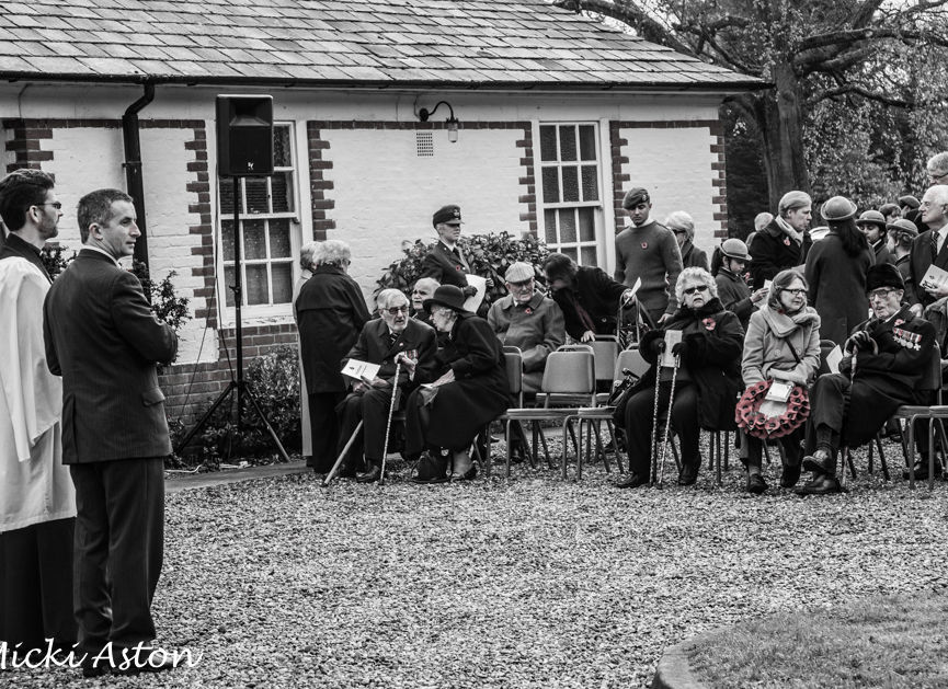 Black and white photograph of a Remembrance Day gathering outside a GXCA building