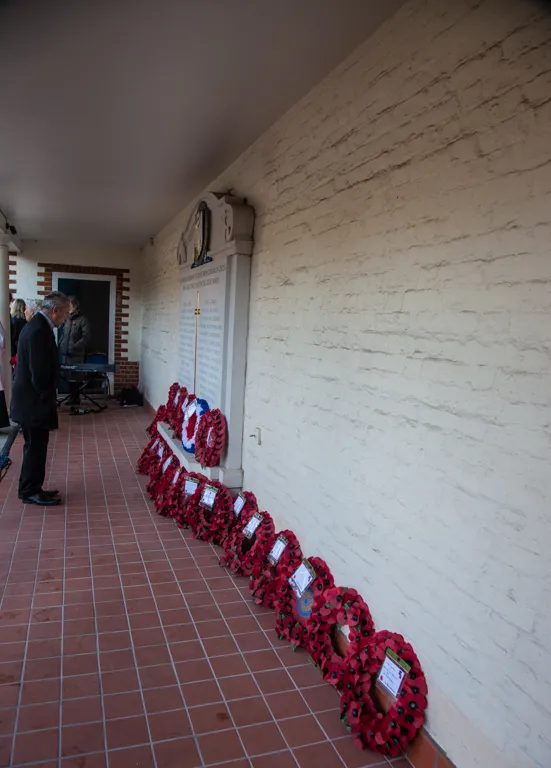Poppy wreaths lining the portico beneath the memorial plaque