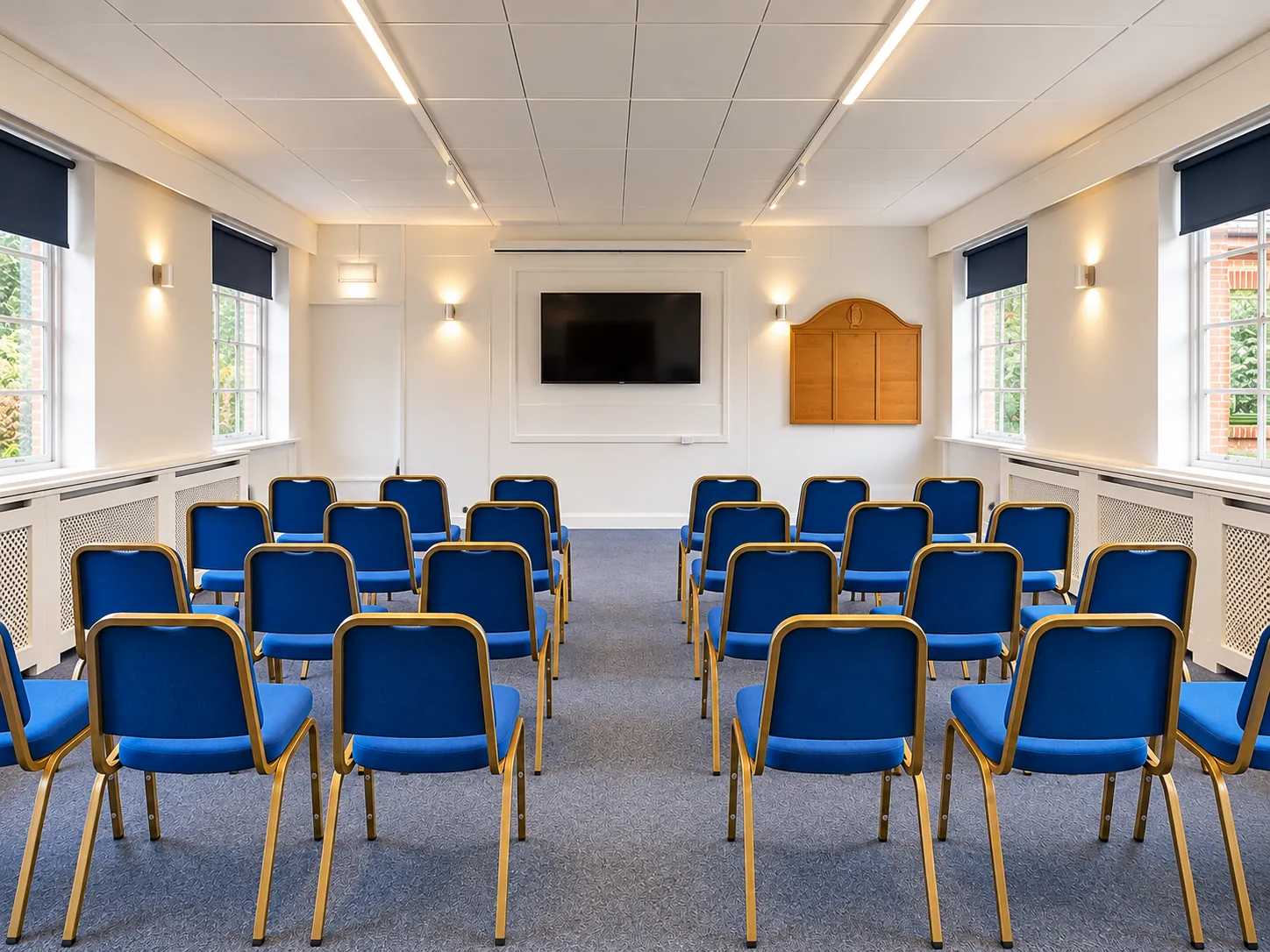 Room 4 set out with rows of blue chairs facing a wall-mounted screen