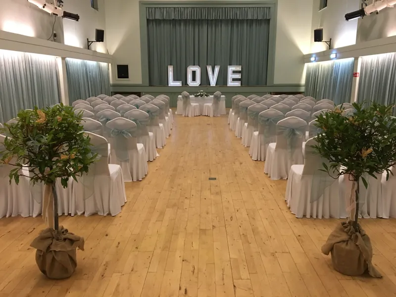 GXCA’s Garden Room set out with white-covered chairs and illuminated ‘LOVE’ letters for a ceremony