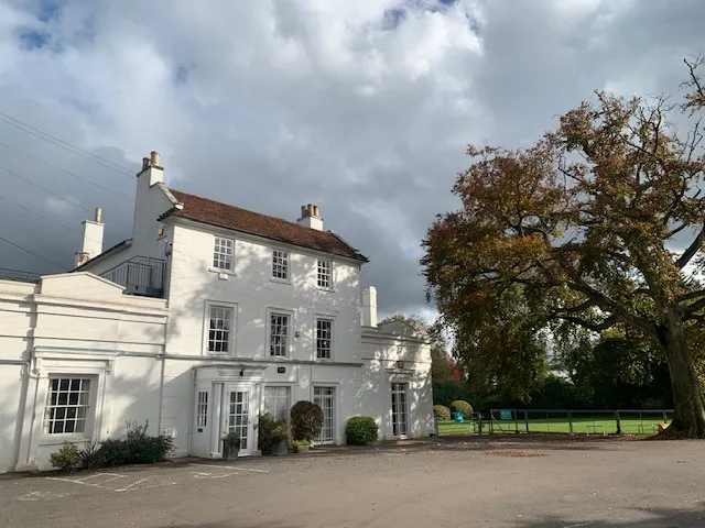 The white Georgian frontage of GXCA’s Memorial Centre wedding venue, with gardens and picnic benches